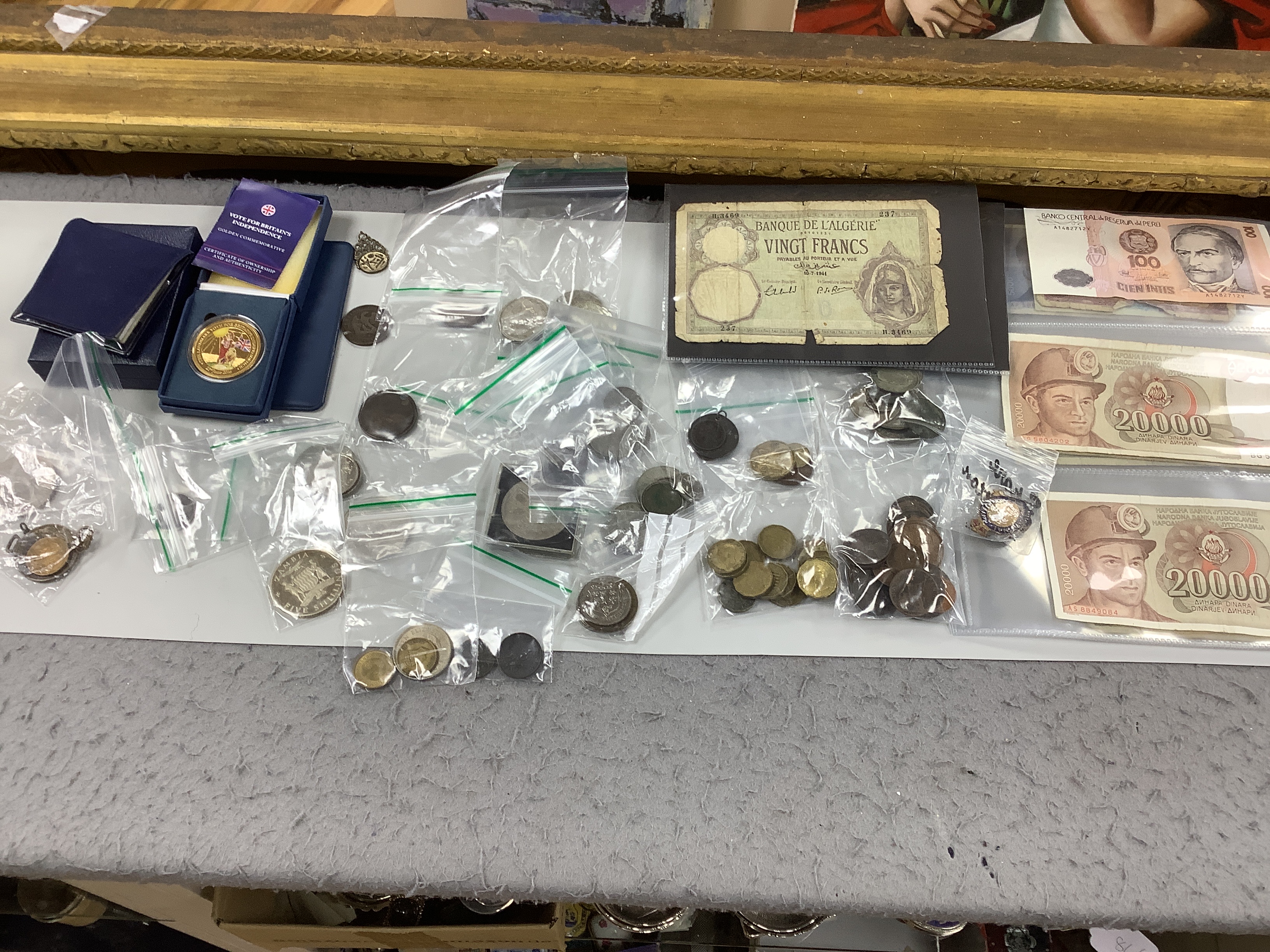 A box of UK and world coins and banknotes, a masonic steel fob seal and a Victorian brass belt buckle
